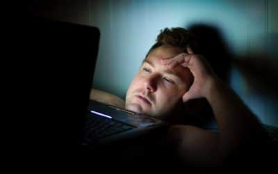 Man with laptop lacking good night's sleep